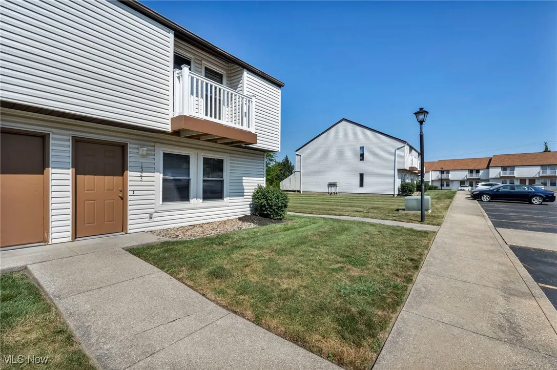 View of property exterior with a balcony and a lawn