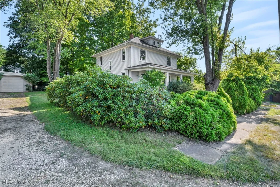 View of side of home featuring a chimney and a garage