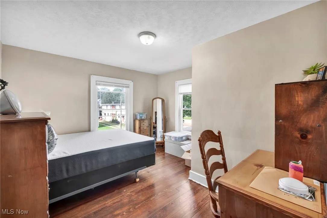 Bedroom with a textured ceiling and dark wood-style floors