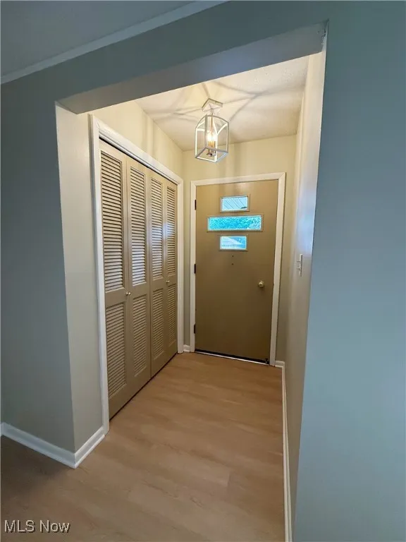 Entryway featuring wood finished floors and a chandelier