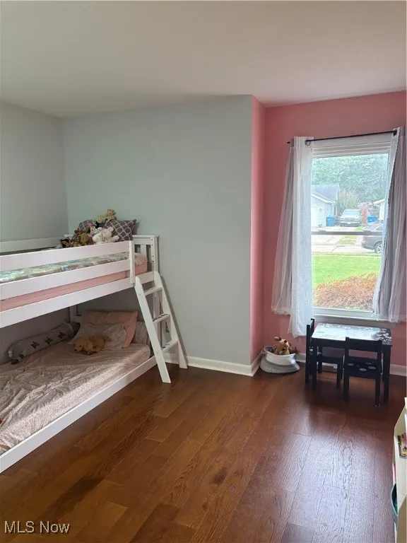 Bedroom with dark wood-style flooring