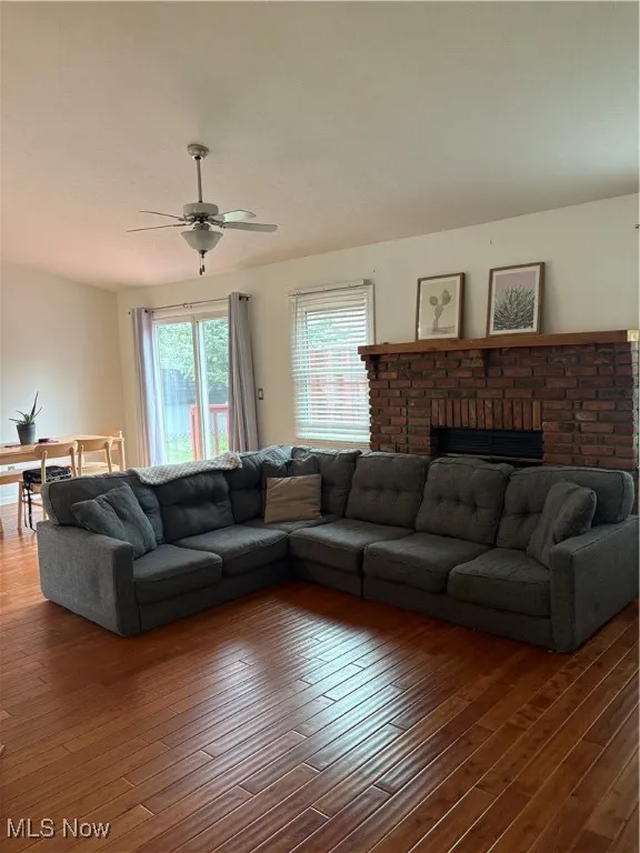 Living room with hardwood / wood-style flooring and a ceiling fan