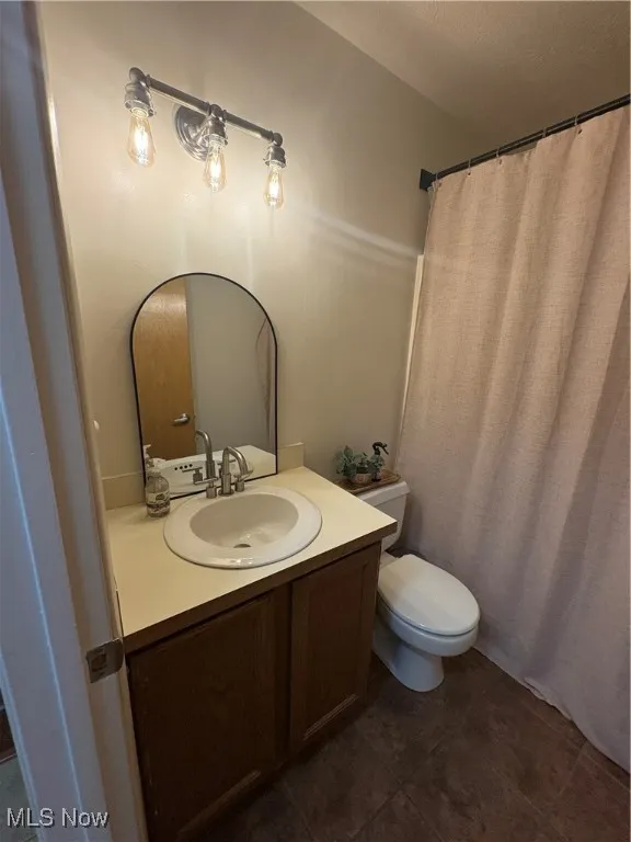 Main Bathroom with vanity and dark tile floors