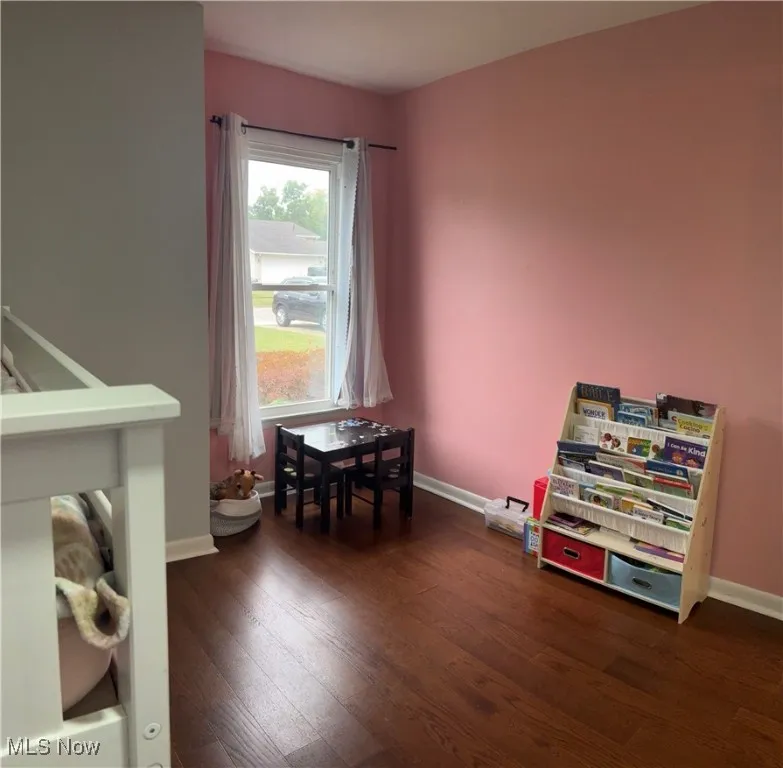 Game room with dark wood finished floors and baseboards