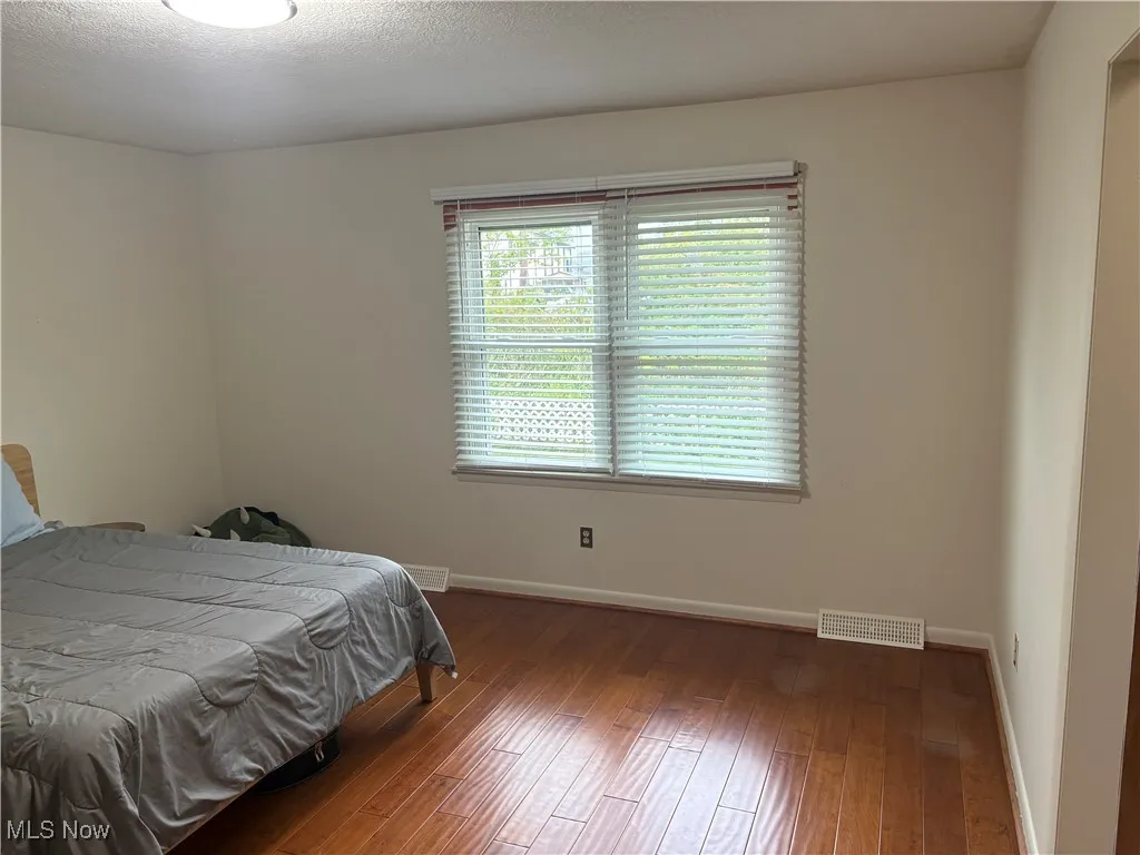 Bedroom with wood-type flooring and a textured ceiling