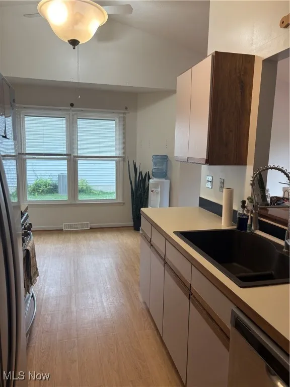 Kitchen with light countertops, light wood-style floors, and dishwasher
