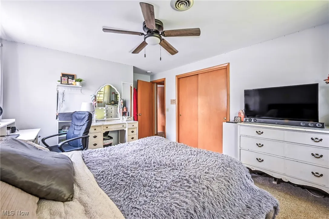 Bedroom featuring carpet flooring, ceiling fan, and a closet