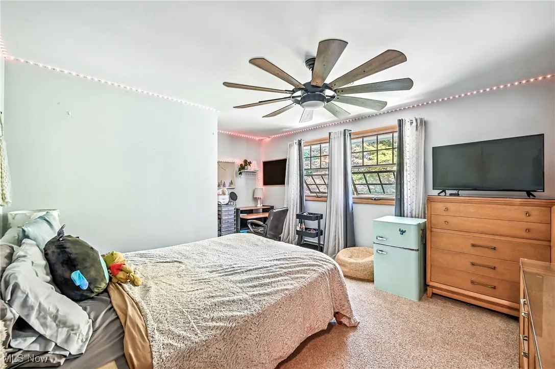 Bedroom featuring light carpet and ceiling fan