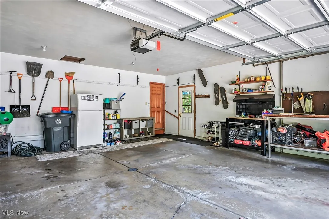 Garage featuring a workshop area, and a garage door opener