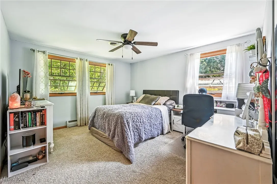 Bedroom featuring carpet floors, ceiling fan, and a baseboard radiator