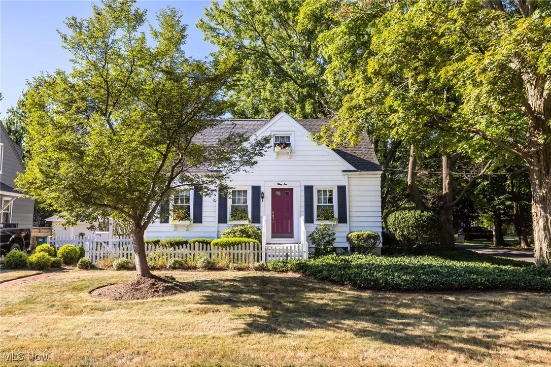 Cape cod-style house featuring roof with shingles
