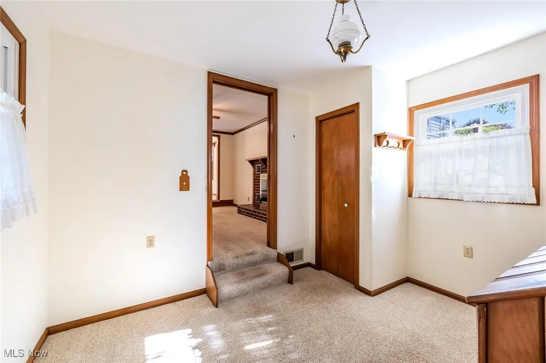 Hallway with carpet flooring and baseboards
