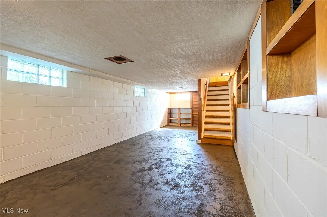 Basement featuring stairs and healthy amount of natural light