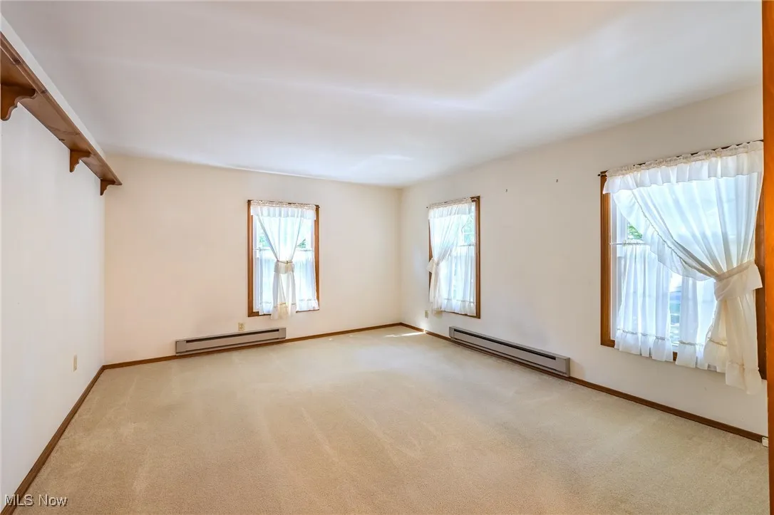 First upstairs bedroom featuring baseboard heating and carpet
