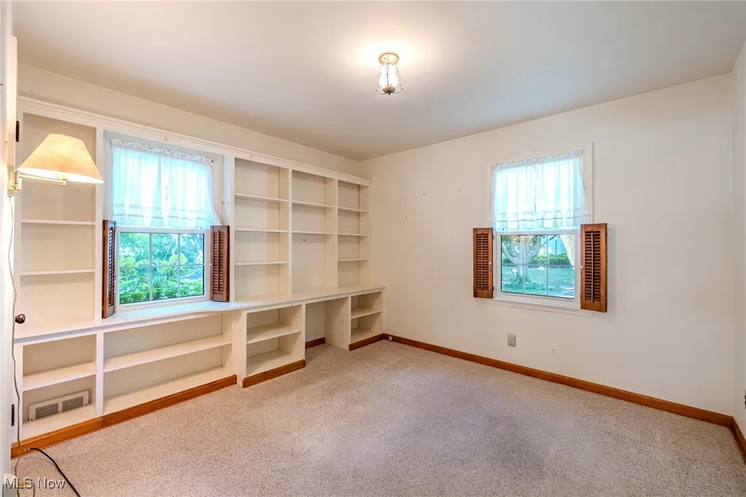 First floor bedroom with light carpet and baseboards