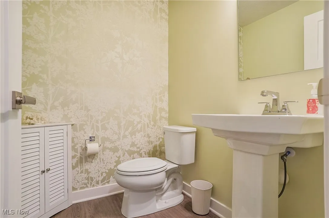 Half bath featuring toilet and wood finished floors
