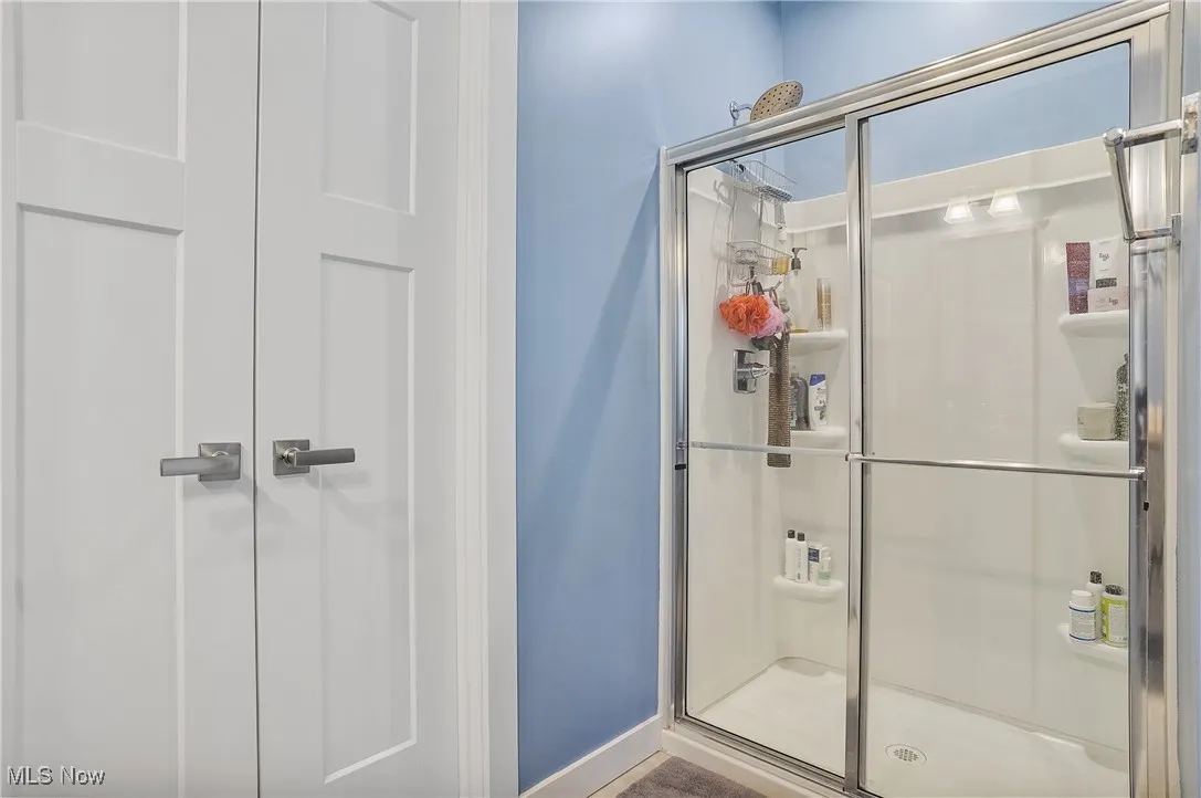 Bathroom with a stall shower and baseboards