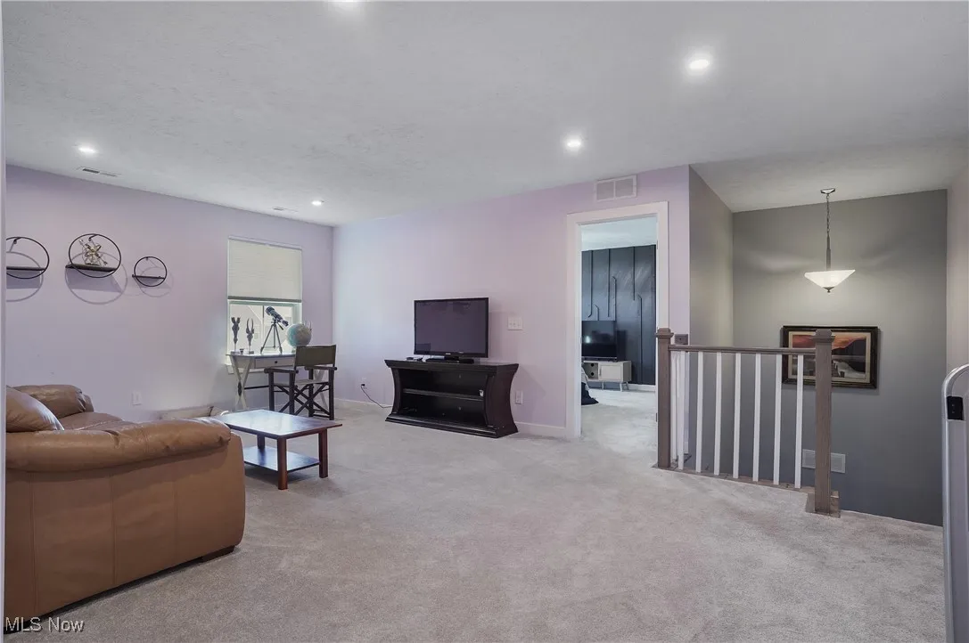 Living room with light colored carpet and recessed lighting