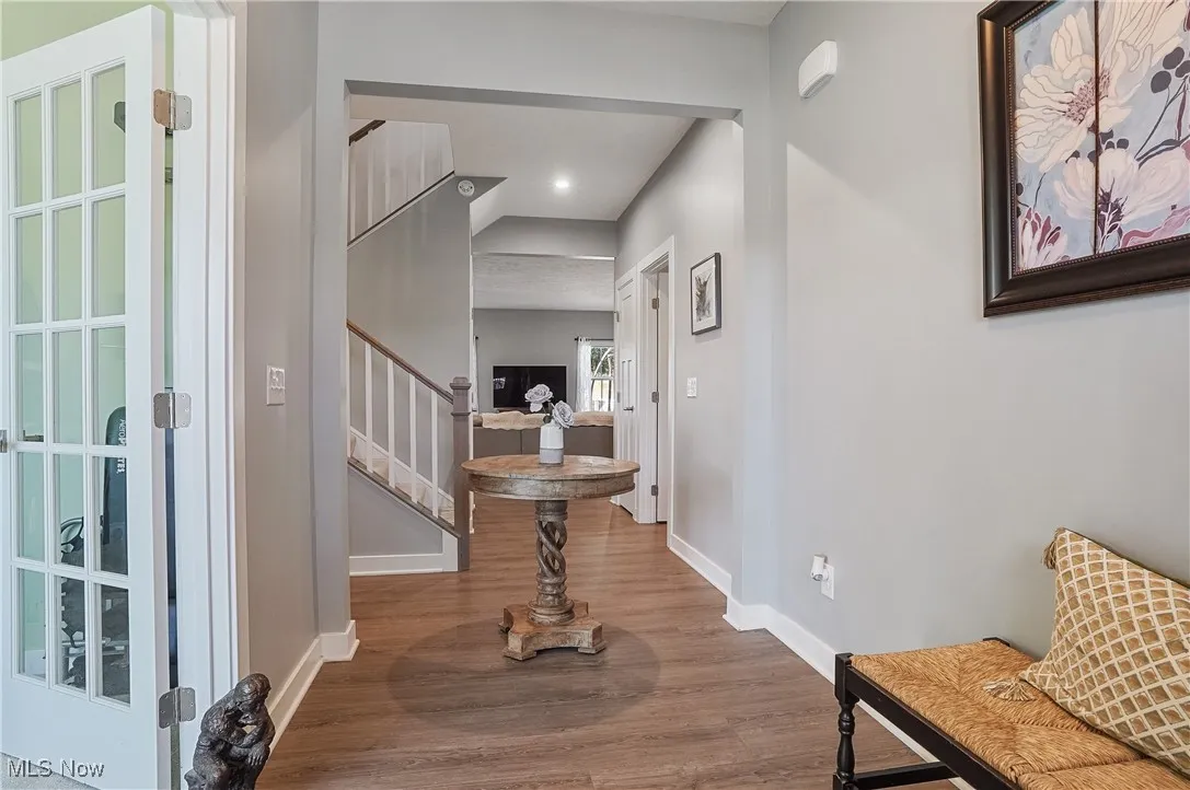 Foyer entrance featuring wood finished floors, stairs, and recessed lighting