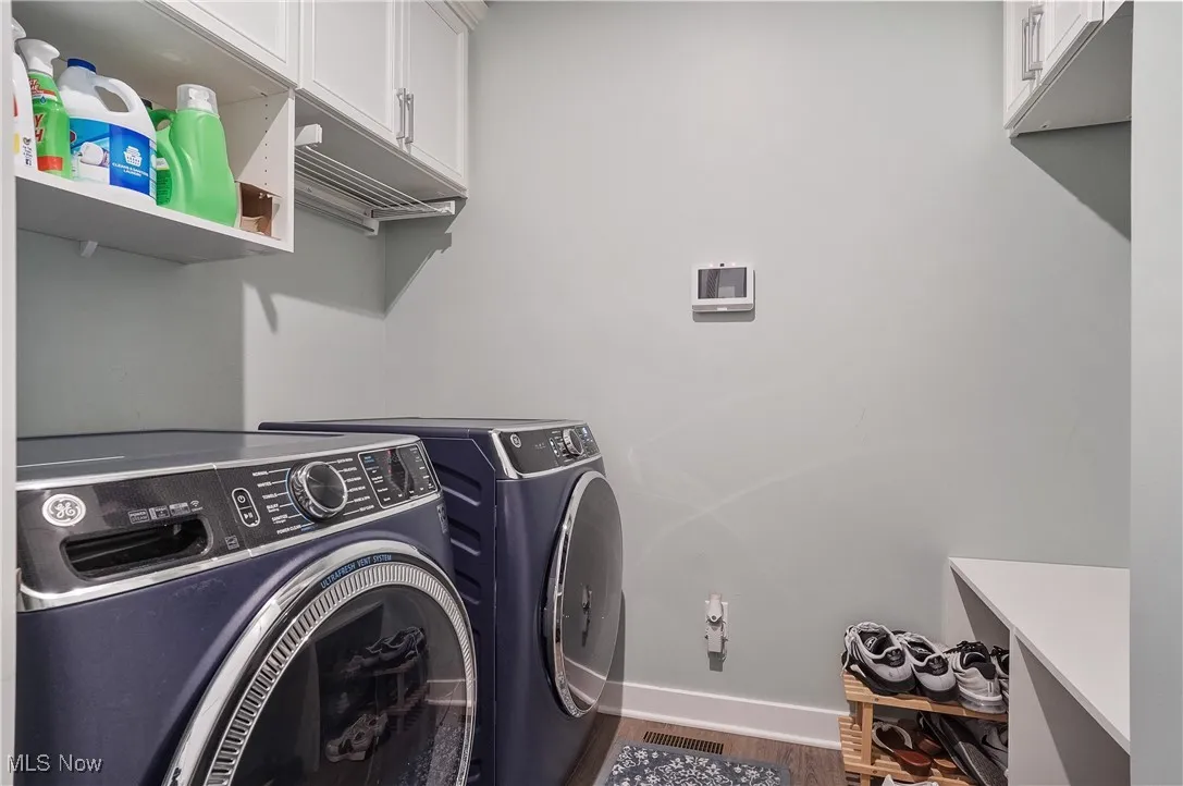 Laundry area with independent washer and dryer and wood finished floors