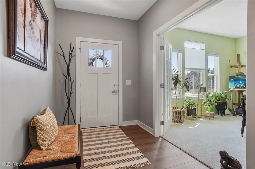 Foyer featuring dark wood-style flooring and baseboards