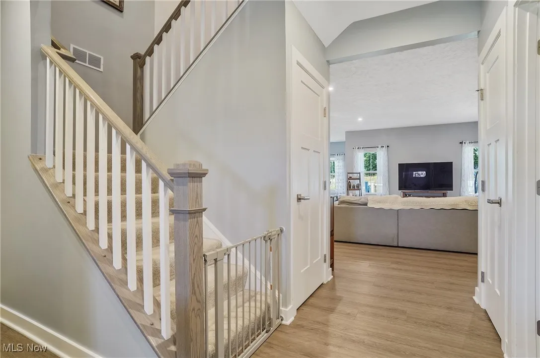 Stairs with wood finished floors and baseboards