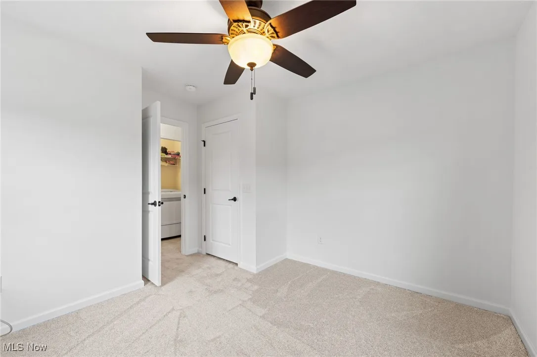 Unfurnished bedroom featuring light carpet and a ceiling fan