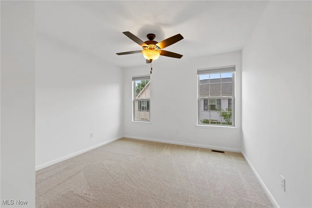 Bedroom featuring light carpet and a ceiling fan