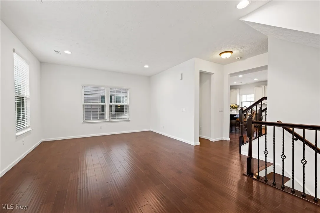 Living room with recessed lighting, dark wood-style floors, stairs, and a textured ceiling