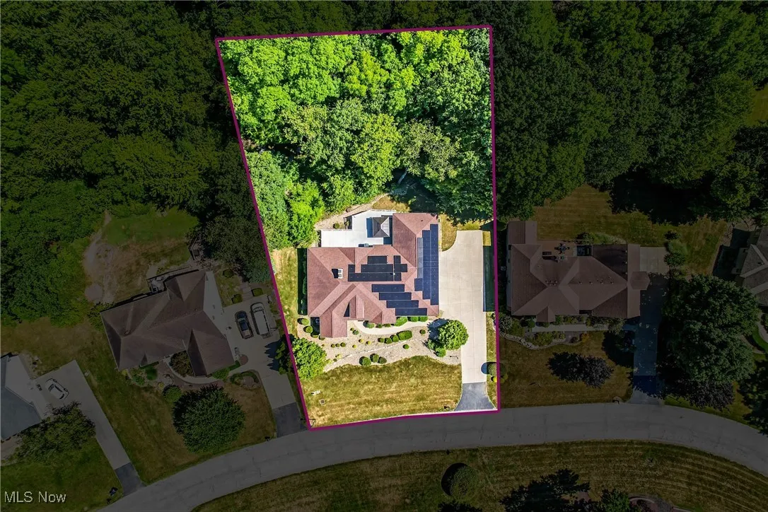Aerial view of property and surrounding area with property boundaries highlighted and a heavily wooded area