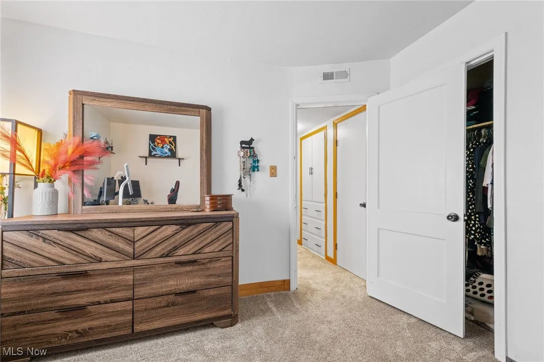 Carpeted bedroom with baseboards and a closet