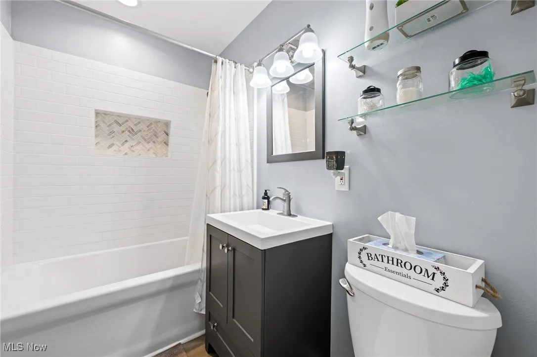 Bathroom featuring shower / bath combo with shower curtain and vanity