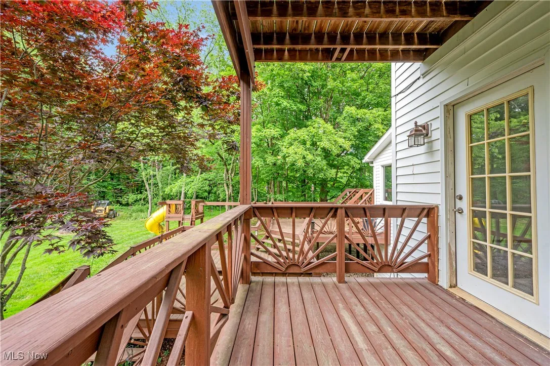 Wooden terrace with a playground and a yard