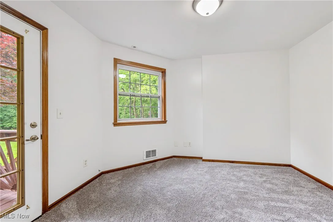 Spare room with carpet and baseboards