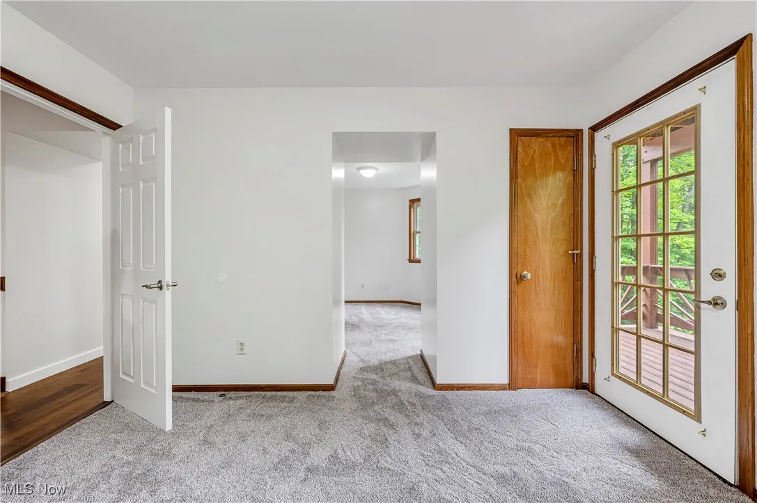 Unfurnished bedroom with light carpet and baseboards