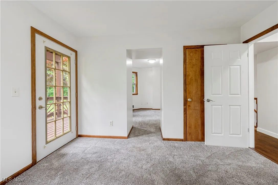 Unfurnished bedroom with access to outside and carpet flooring