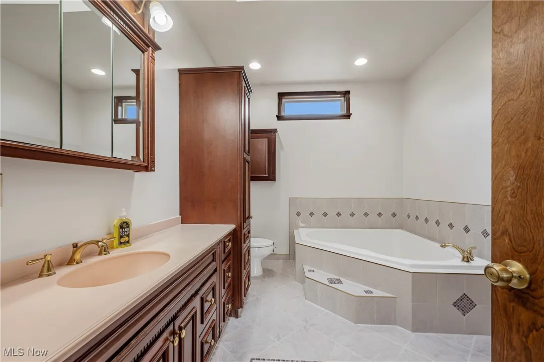Full bathroom with a bath, recessed lighting, vanity, and light tile patterned floors