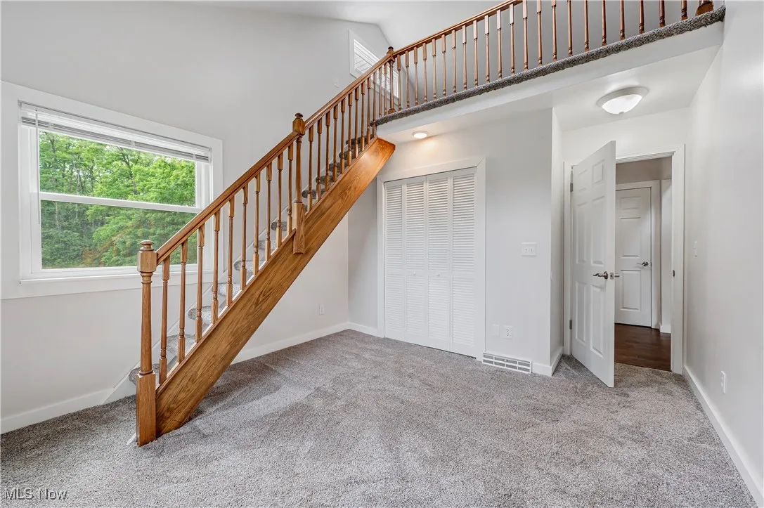 Stairs with a high ceiling and carpet