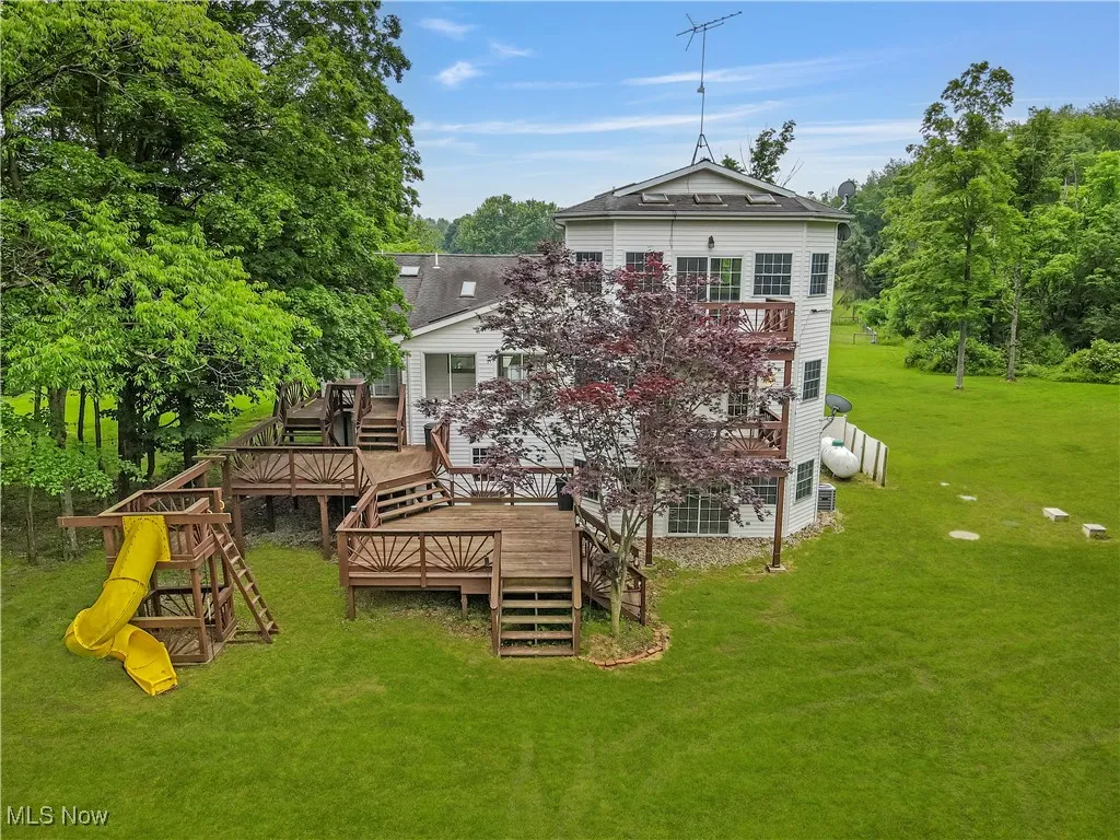 Back of house with a yard, stairs, and a wooden deck