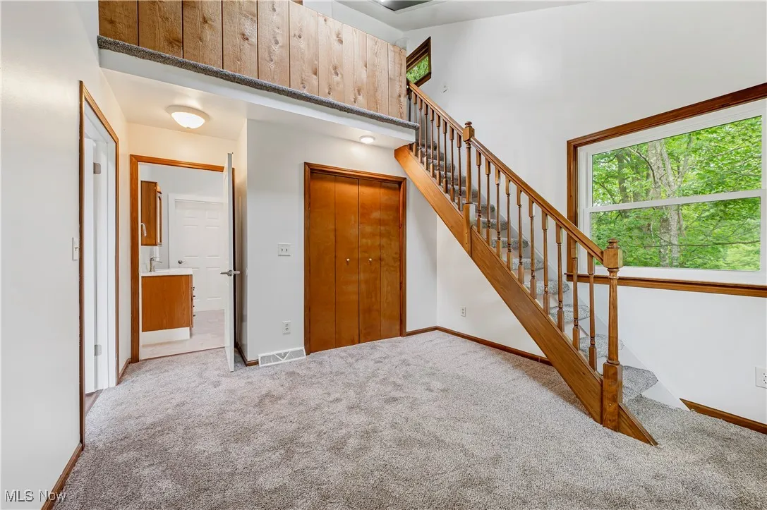 Stairway featuring carpet floors and a towering ceiling