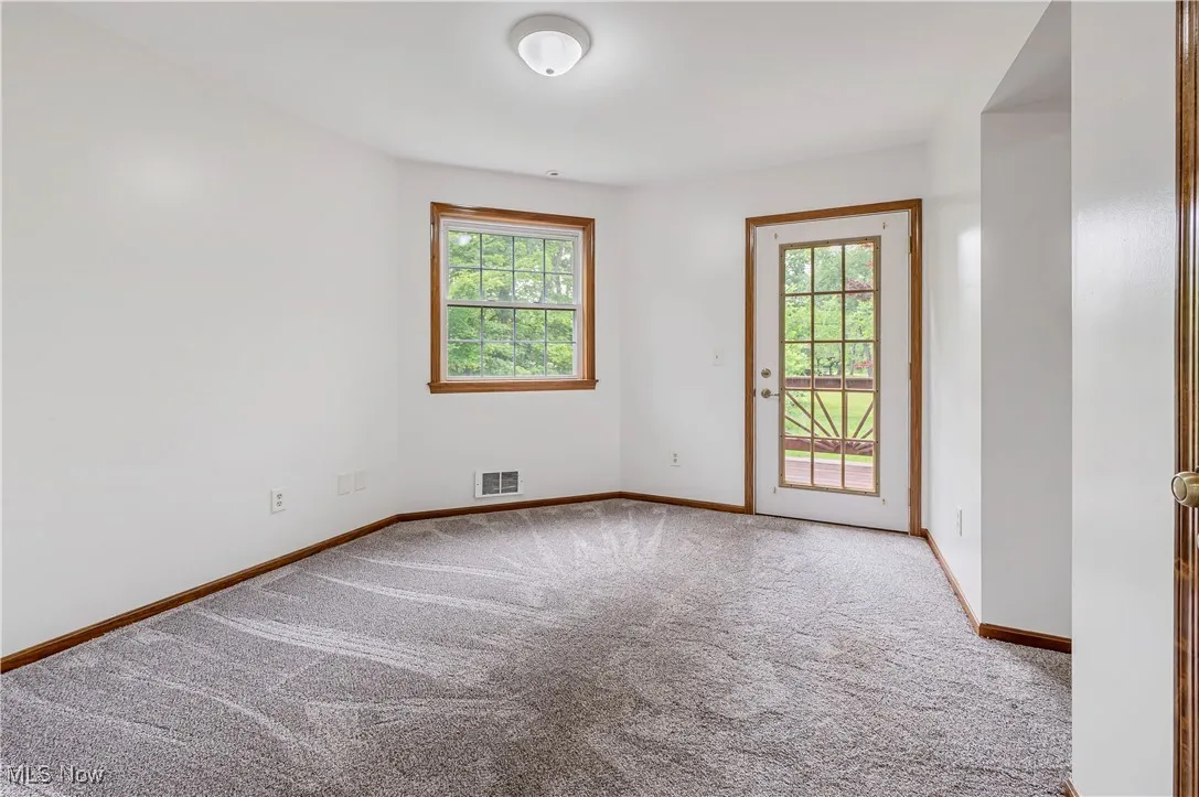 Unfurnished room with healthy amount of natural light and light colored carpet