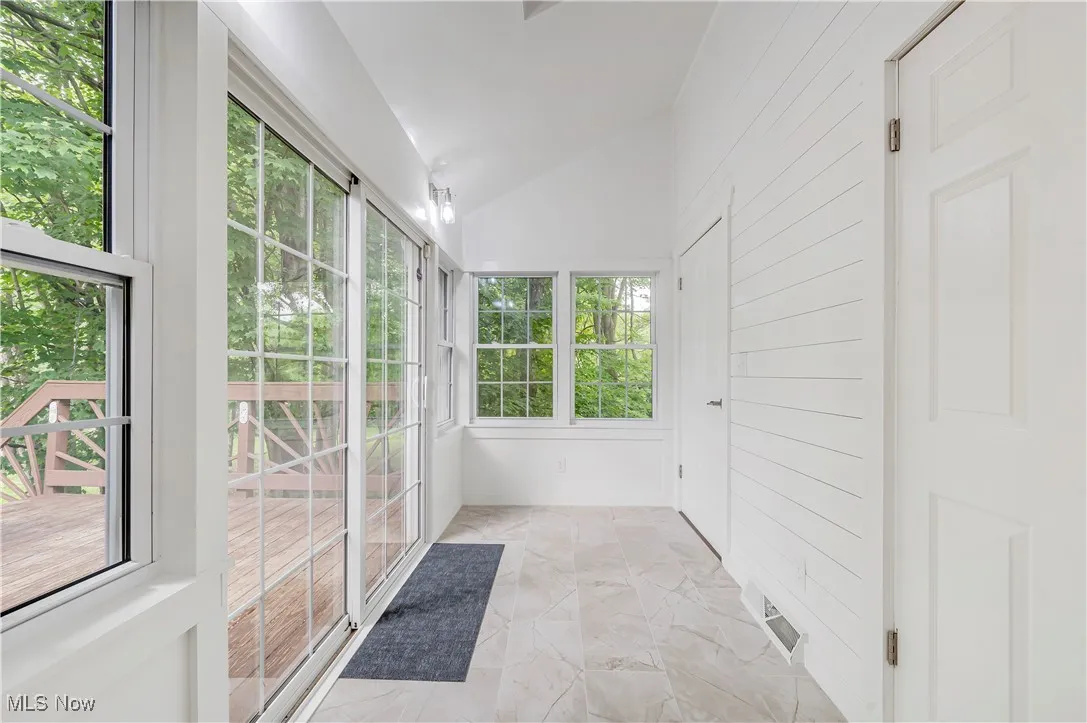 Unfurnished sunroom with lofted ceiling