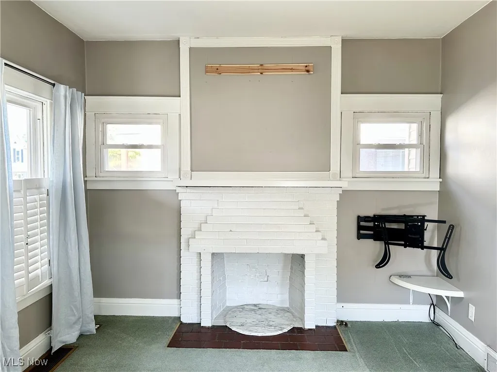 Living room with a fireplace and carpet floors
