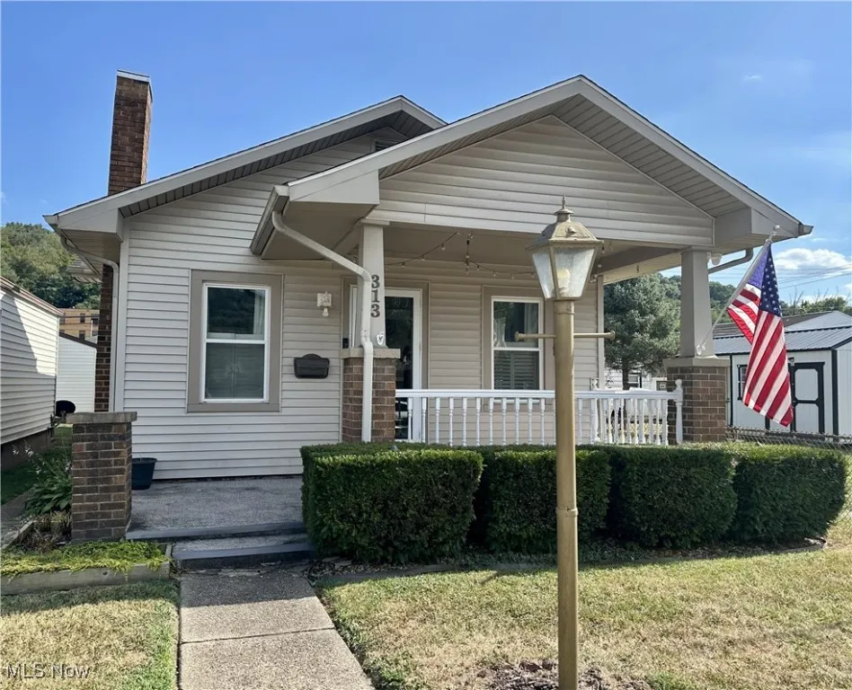 Front view of front of home with covered porch, and a front yard