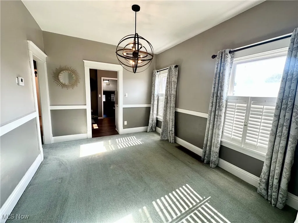 Dining area featuring carpet floors and a chandelier