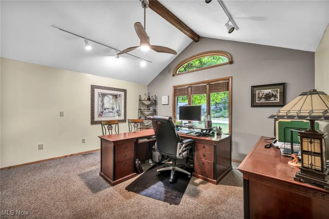 Home office featuring track lighting, light colored carpet, beam ceiling, a ceiling fan, and high vaulted ceiling
