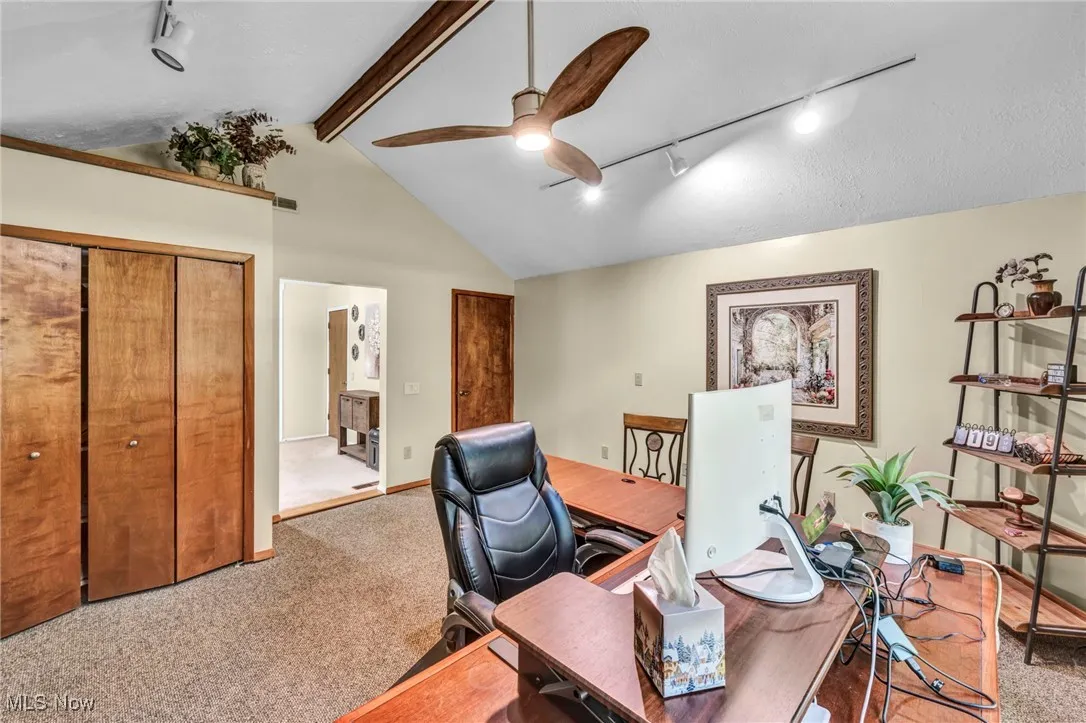 Carpeted office featuring rail lighting, a ceiling fan, beamed ceiling, and high vaulted ceiling