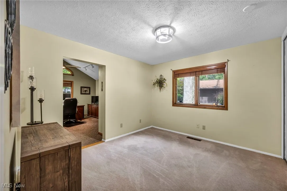 Spare room featuring carpet, a desk, and a textured ceiling