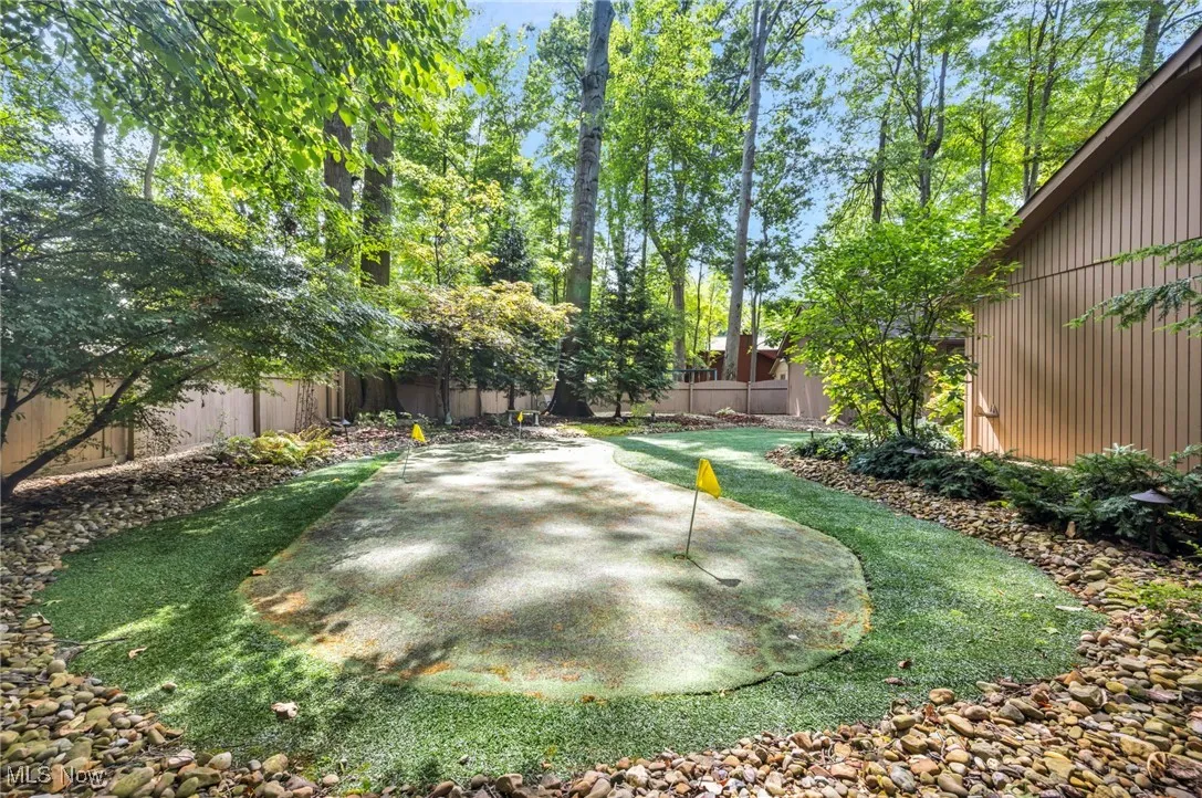 Fenced backyard with an area to practice putting