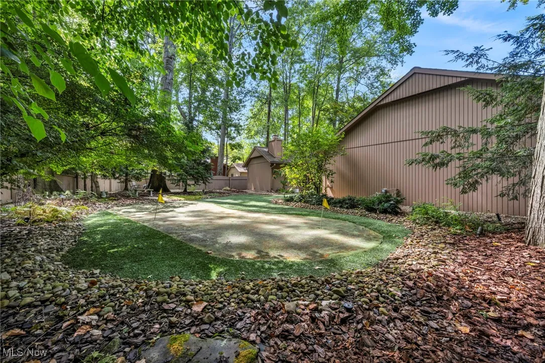 Fenced backyard featuring a putting area